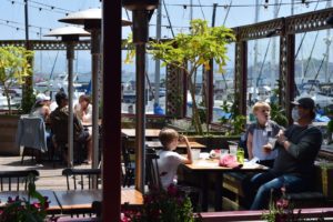 Outdoor dining with ships in the harbor