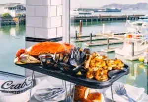 Crab House at Pier 39 in San Francisco, Killer Crab and mussels and shrimp on a sizzling iron skillet with the waterfront Bay views in the background